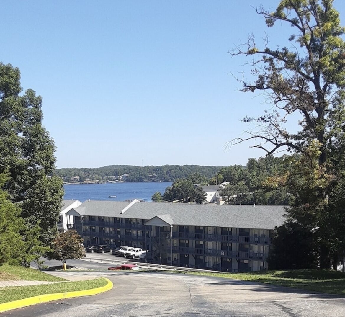 A building with a parking lot and a view of a body of water.