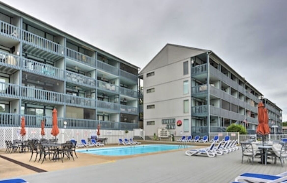Un hotel con varios balcones, piscina y zonas de estar al aire libre.