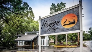 A billboard for Heron Bay at the 21mm with a bird silhouette on a sunset background.
