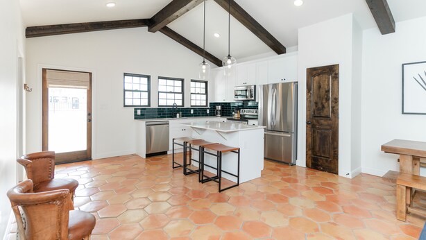 A spacious kitchen with a large island, wooden beams, and a tiled floor. - La Palmilla Texas (Glen Rose)