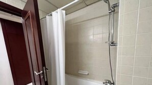 A bathroom with a shower, a bathtub, and a toilet.