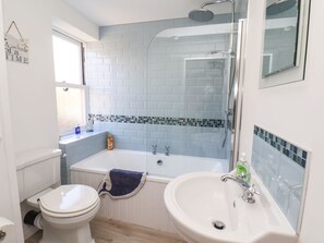 A bathroom with a toilet, a bathtub, and a sink. - Navigators Rest (Whitby)