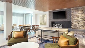 Un'area lounge moderna con un tavolo rotondo, divani e un camino.