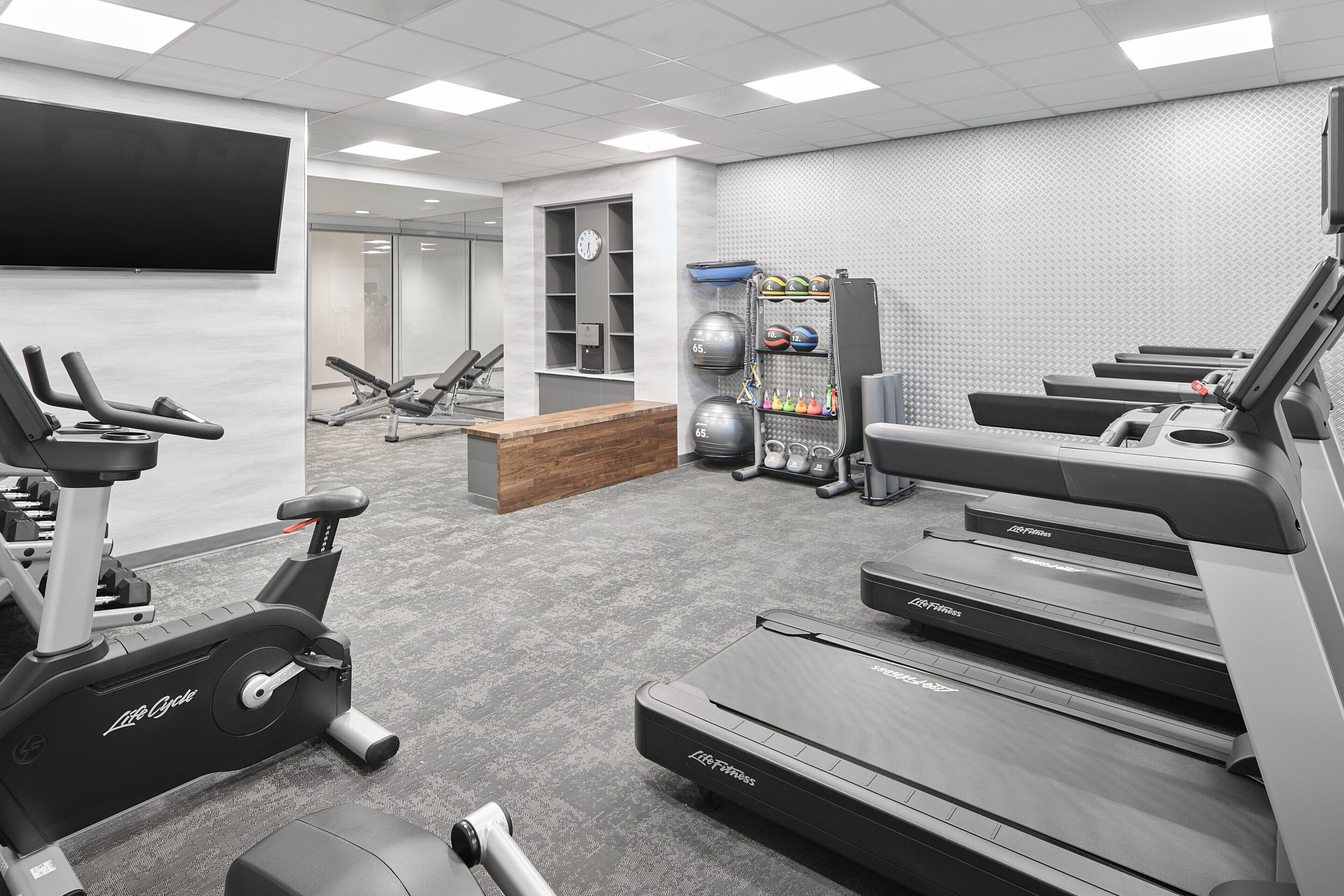 A gym with treadmills, stationary bikes, and weight machines.