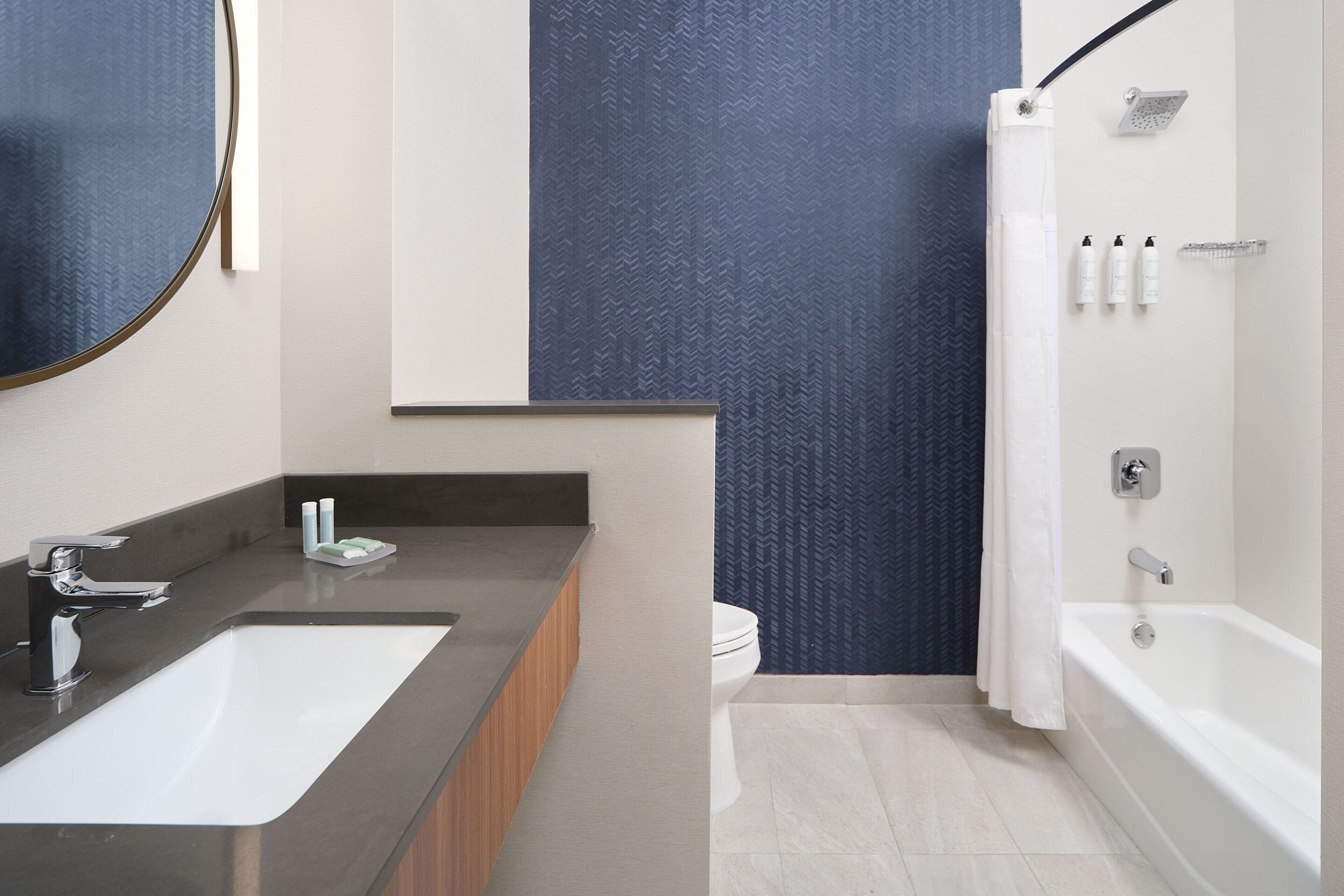 Een moderne badkamer met een groot wastafel, een bad en een douche.