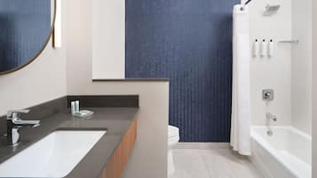 Een moderne badkamer met een groot wastafel, een bad en een douche.