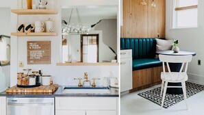 Une cuisine moderne avec des étagères en bois, un évier de style vintage et un panneau décoratif. Elle comprend également un coin salon confortable avec un canapé de couleur turquoise et une petite table ronde.