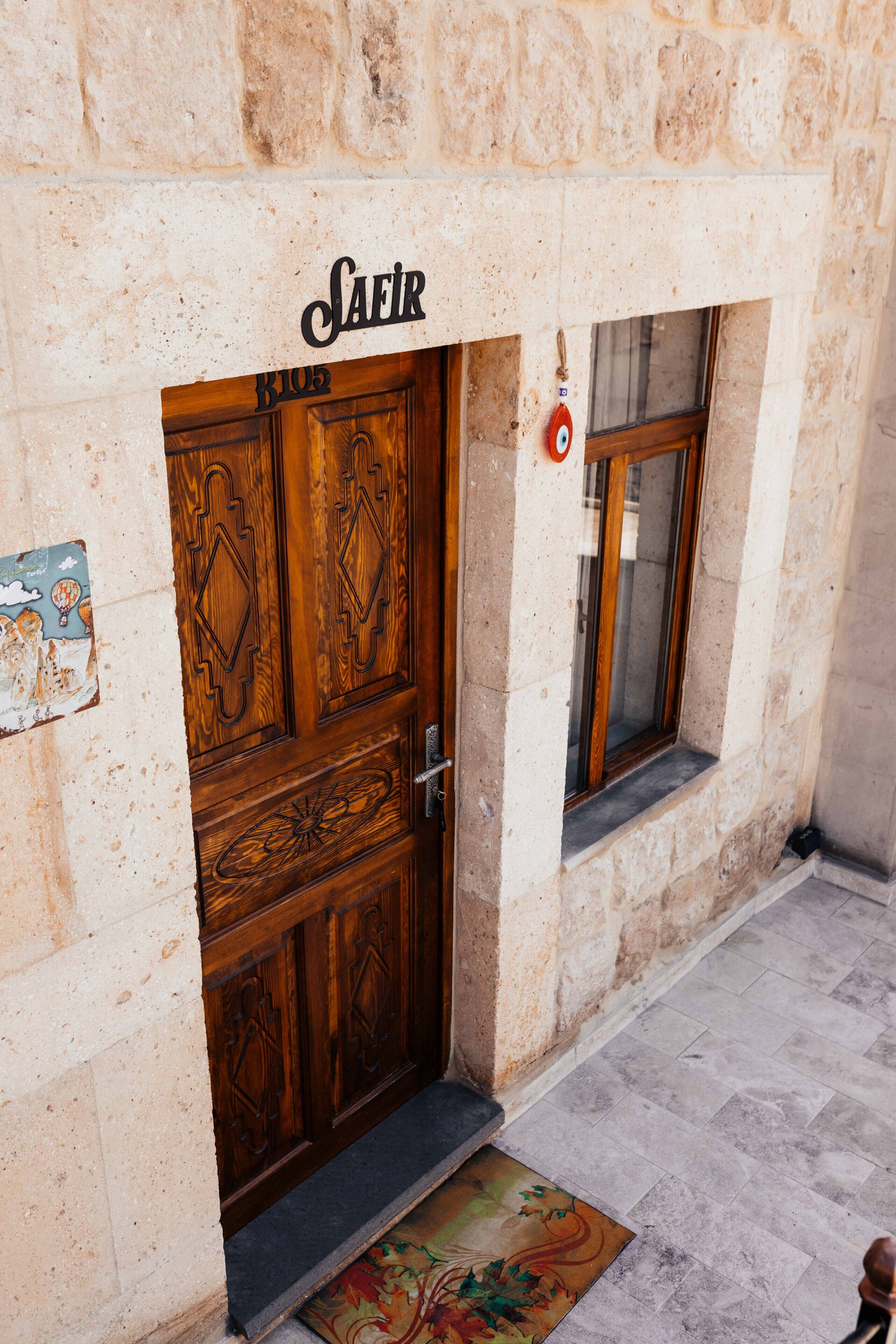 A stone building with a wooden door labeled "SAFIR."