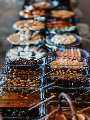 Un buffet proposant divers plats présentés dans des récipients en verre.