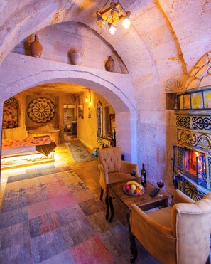 Ein gemütliches Interieur mit Kamin, einem Essbereich mit Tisch und Stühlen sowie einer dekorativen Decke.
