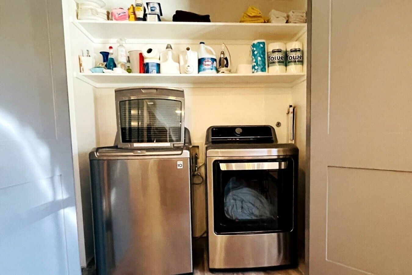 Un espace buanderie compact comprenant un réfrigérateur et un lave-linge.
