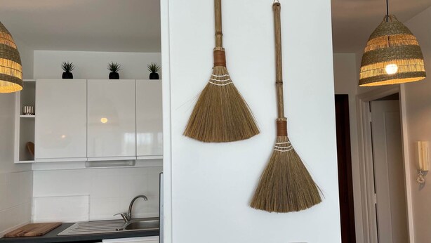 A kitchen with white cabinets, a sink, and a cutting board. - Côté Thalasso (Quiberon)