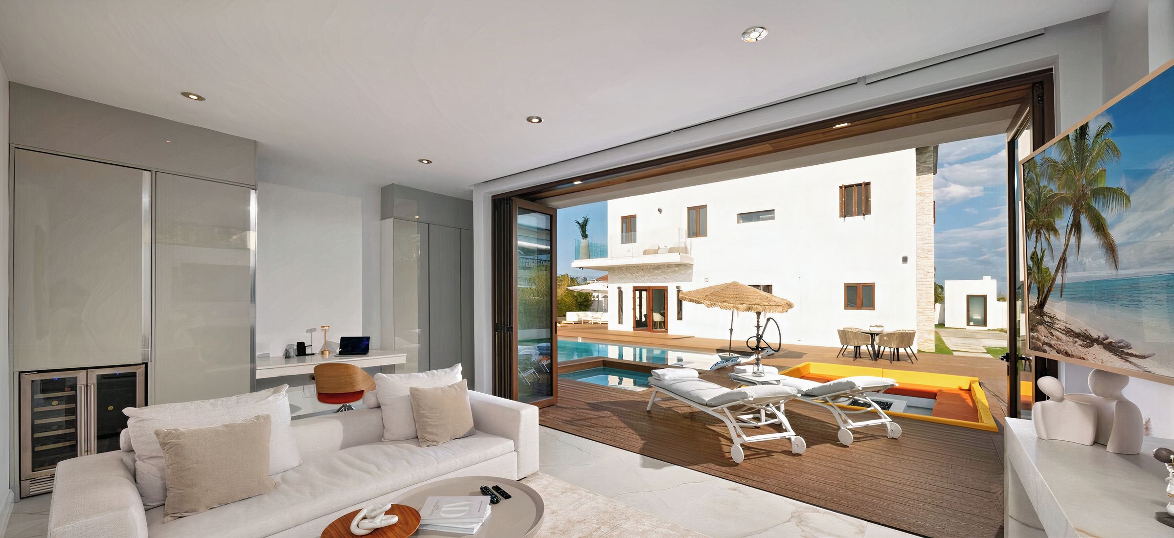 Una sala de estar moderna con un sofá blanco, un ventanal de vidrio que da a una zona de piscina y vistas a un edificio blanco con piscina.