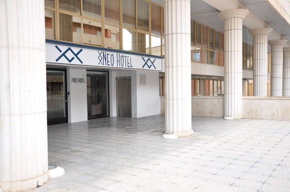A hotel entrance with a sign reading "NEO HOTEL" and a modern architectural design featuring large columns and a tiled floor. - NEO HOTEL (Caravaca de la Cruz)