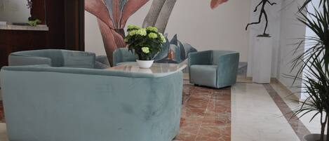 A lobby with a large floral mural, a reception desk, and seating areas.