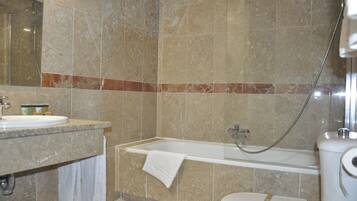 Een badkamer met een bad, toilet en wastafel.
