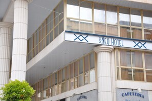 A hotel with a prominent 'Xneo Hotel' sign, a 'CAFETERIA' sign, and large windows on the upper floor. - NEO HOTEL (Caravaca de la Cruz)