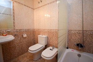 A bathroom with a toilet, bidet, sink, and bathtub.
