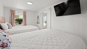 A hotel room with two beds, a flat-screen TV, and a window with curtains. - Pet-Friendly, Steps to the Beach Seahorse Ranch #1 (North Myrtle Beach)