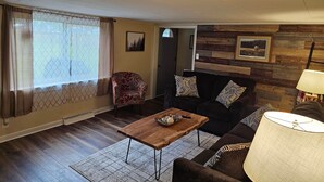 Un salon avec une table basse en bois, un canapé, un fauteuil et une lampe.