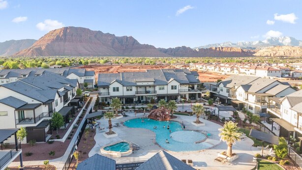 A resort with multiple buildings, a central pool area, and a mountainous backdrop. - Waterpark overlook with patio, firepit, pickleball (Santa Clara)