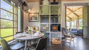 A dining area with a round table, chairs, and a fireplace. - Ultimate Constable Country retreat -The Pump House (Colchester)