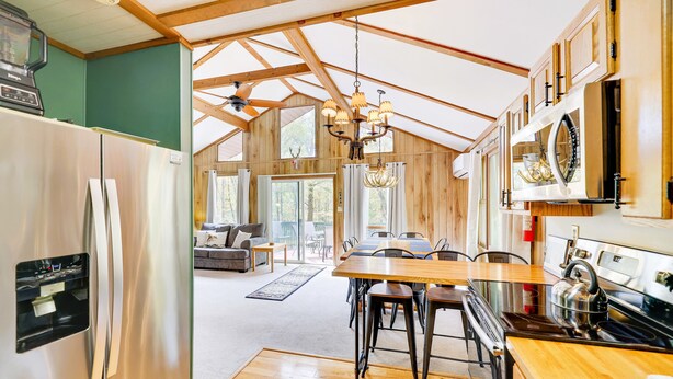 A spacious kitchen with a large island, stainless steel appliances, and wooden beams.