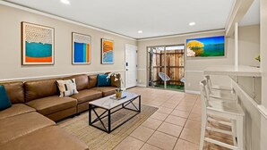 A living room with a brown sofa, a coffee table, and artwork on the walls.