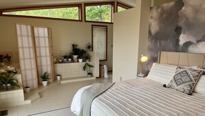 A bedroom with a large bed, a window with blinds, a bedside lamp, and a wall-mounted TV. - Gorgeous mountain view - 3 minutes from Downtown Asheville (Asheville)