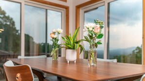 A wooden dining table with three vases of flowers. - Gorgeous mountain view - 3 minutes from Downtown Asheville (Asheville)