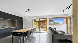 Et moderne køkken med spiseplads, en sofa og udsigt til det fri.