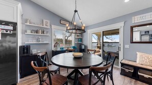 A modern kitchen with a round dining table, chairs, and a built-in water dispenser.