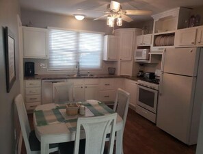Enjoy cooking in this well-equipped kitchen with a central island, microwave, stove, and refrigerator.