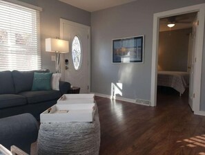 Relax in this inviting space with a sofa, side table, and comfortable bed nearby.