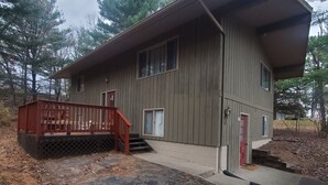 A two-story wooden cabin with a covered porch and a small staircase leading to the entrance. - Lake Delton ~ Wisconsin Dells Home Provides Comfort and Access to All Activities (Wisconsin Dells)