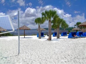 Relax by the beach with a volleyball net and shaded areas, perfect for a leisurely day.