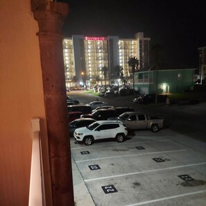 A hotel with a prominent sign, a parking lot with marked spaces, and a building with multiple floors.