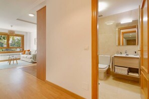 A modern bathroom with a toilet, sink, and mirror.
