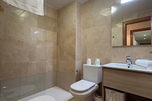 Ein Badezimmer mit Toilette, Waschbecken und Spiegel.