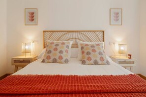 A bed with a patterned headboard, two bedside lamps, and a red blanket. - 624A Charming Downtown Apartment by R2R Consulting (Oviedo)