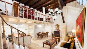 Amplia sala de estar con una escalera, comedor y una zona de estar acogedora.