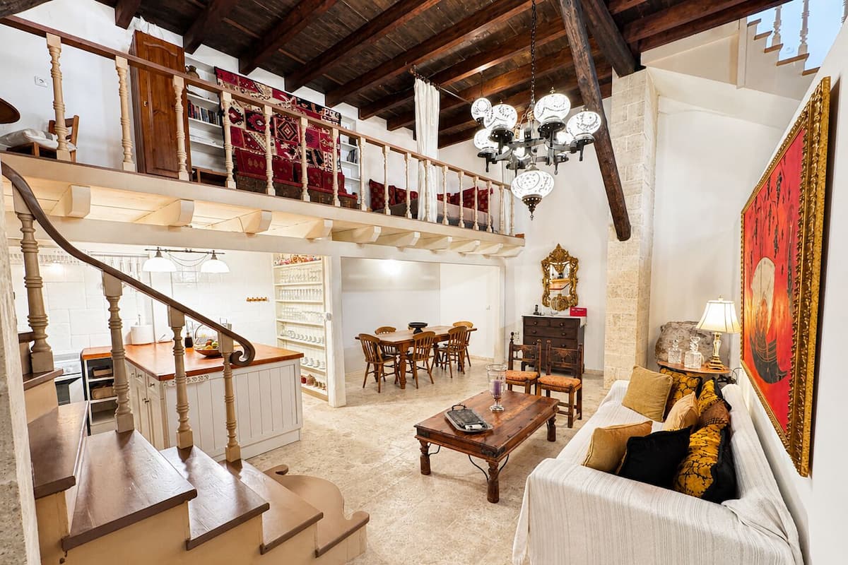 Uma sala de estar ampla com escada, área de jantar e um espaço de estar aconchegante.