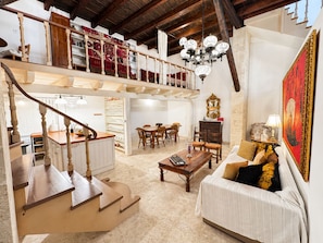 Uma sala de estar ampla com escada, área de jantar e um espaço de estar aconchegante.