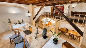 Una habitación espaciosa con techo alto, una escalera, un comedor y una cocina.