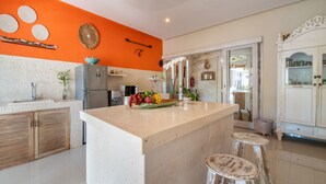 A kitchen with a large island, wooden cabinets, and a white countertop.