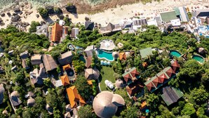 Une vue aérienne d’un complexe hôtelier doté de plusieurs piscines, d’une plage et de différents bâtiments à l’architecture originale.