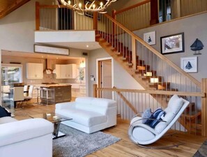 Relax in this stylish living area with a leather sofa, glass coffee table, and a unique rocking chair.