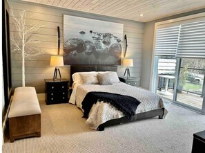Relax in this serene bedroom with a large bed, two nightstands, and a beautiful abstract painting.