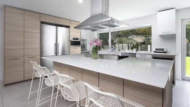 A modern kitchen with a large island, stainless steel appliances, and a view of the outdoors. - Austin Lux 4BR w/Wellness Center-Heated Pool/Sauna & Cold Plunge in Westlake (Austin)
