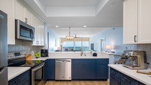 A modern kitchen with stainless steel appliances, a dishwasher, and a coffee machine.